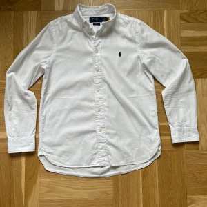 Polo Ralph Lauren skjorta  - Storlek- 16år                                                                   Skick- 8/10 en lapp på bild 2 har släppt i en sömn.                                                                              Modell- slim fit.                                                           Pris- 399 kan gå ner vid snabb affär.                  