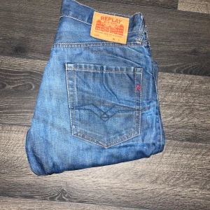 Replay jeans  - Säljer ett par klassiska blå jeans från Replay med raka ben och normal passform. Jeansen har fem fickor, snygga kontrastsömmar och läderpatch bak i midjan. Tillverkade i slitstarkt denimtyg som ger en tidlös look. Midja 39cm längd 110cm. Passform straight. KAN TYVVÄR EJ SKICKA BILD NÄR JAG BÄR DEM DÅ JAG EJ KAN HA STORLEKEN UTGÅ IFRÅN MÅTTEN FÖR STORLEK :)