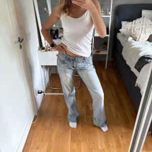Ljusblåa wide jeans från Replay - Säljer ett par ljusblåa jeans från Replay med snygga detaljer på bakfickorna, dragkedjor och knappar. Jeansen har låg midja och en loose, wide passform som ger en avslappnad vibe. Perfekta för dig som gillar streetstyle och vill ha något bekvämt men stilrent.                                    Skulle säga storlek M men de sitter såhär på mig som har S❤️