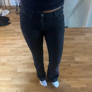 Svarta bootcut jeans från Lee - Säljer ett par svarta jeans från Lee med bootcut-modell. Jeansen har klassisk femficksdesign, låg midja och är tillverkade i stretchig denim för en bekväm passform. Snygga till sneakers eller boots och perfekta för dig som gillar en tidlös look.