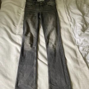 Lowwaist bootcut jeans - Snygga grå jeans från Bershka i bootcut-modell. Lite slitna längst ner och säkert uttänjda eftersom de har använts, annars i fint skick🥰Säljer då de tyvärr är försmå.