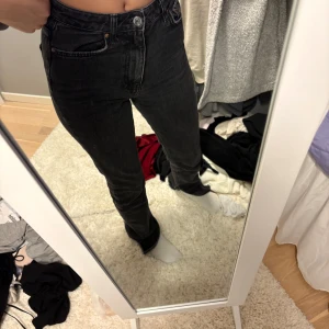 Svarta jeans  - Säljer ett par svarta jeans som är tighta i början och sen går de ut och är en slits längst ner. De ser avklippta ut men de är dom inte, de köptes så de skulle se avklippta ut. 😊är i storlek 32 och kommer ifrån Gina tricot, köptes för många år sedan och är inte använda mycket. 🖤