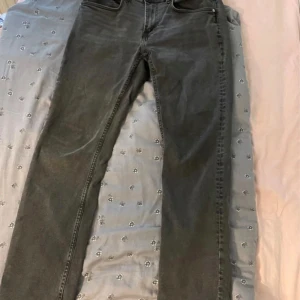 Svarta jeansbyxor från 157, W33 L32 - Säljer ett par svarta jeansbyxor från 157 i klassisk femficksmodell. Byxorna har rak passform och normal midja, perfekta till en avslappnad stil. Materialet är jeans och färgen är snyggt urtvättad svart.