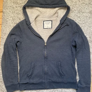Fodrad cardigan med luva Abercrombie & Fitch - Säljer en riktigt fet mörkblå hoodie från Abercrombie & Fitch. Storlek S och passar mig som har M bra också. Bra skick