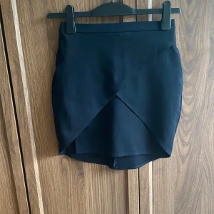 Svart kjol - Dragkedja bak. Materialet känns mjukt och har lite stretch