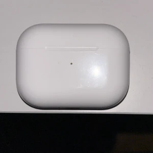 AirPods Pro - Apple AirPods Pro med laddningsetui. Trådlösa hörlurar med aktiv brusreducering och bekväm passform. Skalet och hörlurarna ser ut att vara i gott skick med endast mindre tecken på användning. Perfekt för musik, samtal och träning.