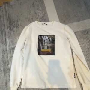 Vit långärmad tröja Roberto Vino - Säljer en vit långärmad tröja från Roberto Vino med ett stort Milano-inspirerat tryck på bröstet. Tröjan har rund halsringning och är i mjuk bomull, perfekt för dig som gillar stilrena plagg med coolt print.