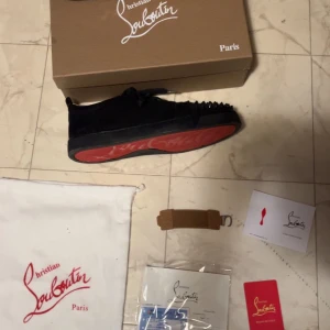 Christian Louboutin svarta sneakers med nitar - Beskrivning: helt nya Loubs, andvänd en ända gång. Storlek 44 på de och de medföljer med alla tillbehör på bilden som tillexempel dustbag kartong och tillome kvittot på bilden. Däremot är de inte riktiga!!!
