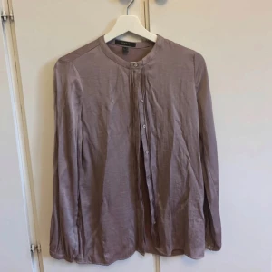 Ljuslila skjorta från Esprit - Säljer en stilren ljuslila skjorta från Esprit i storlek 34. Skjortan har lång ärm, knappar framtill och en enkel, rak passform. Materialet känns mjukt och lätt, perfekt för en clean och avslappnad look.