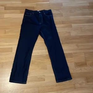 Mörkblå jeans från  Gina , stl 42 - Snygga mörkblå jeans från Perfect Jeans i klassisk rak modell. Jeansen har fem fickor, kontrastsömmar och normal passform. Perfekta till en avslappnad stil och funkar året runt. Materialet är klassisk denim som känns både slitstarkt och bekvämt.
