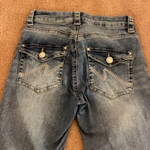 Blå jeans från Nelly med fickdetaljer - Ett par snygga bootcut jeans från nelly. Skriv om ni vill ha bättre bilder💘