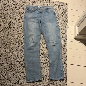 Jack & Jones Loose Fit Ljusblå Jeans - Ljusblå jeans från Jack & Jones i modellen Loose/Chris. Klassisk femficksdesign med raka ben och avslappnad passform. Tillverkade i slitstarkt denim med kontrastsömmar. Perfekta för dig som gillar en loose och bekväm stil.