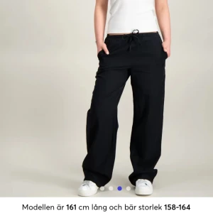 Svarta linne byxor från Gina Tricot - Svarta linnebyxor från Gina Tricot i storlek 158/164. Vida ben, resår i midjan och snörning för extra komfort. Tillverkade i mjukt bomullsmaterial och linne, perfekta för en chill och avslappnad stil. Snygga att matcha med sneakers och en enkel topp. litet hål vid snöret som säkert går att fixa