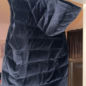 Mörkblå manchesterväst  - Supersnygg mörkblå klänning i mjuk manchester med quiltad struktur. Klänningen har kort ärm och en cool, oversized känsla. Perfekt för dig som vill sticka ut med en unik och trendig look.