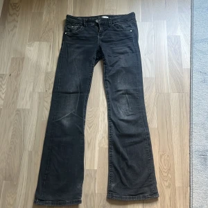 Svarta bootcut jeans Gina Tricot 164 - Svarta jeans från Gina Tricot i storlek 164. Modellen har klassisk femficksdesign, raka ben med lätt utsvängning nertill och snygga detaljer på bakfickorna med knappar. Jeansen är i ett mjukt denimtyg och passar perfekt till en avslappnad stil
