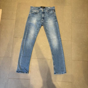 Replay Grover ljusblå jeans, stl 32 - Säljer ett par Replay Grover jeans i ljusblå tvätt. Klassisk femficksmodell med snygga slitningar och raka ben. Jeansen har normal passform och är tillverkade i mjukt denimtyg som sitter skönt hela dagen.