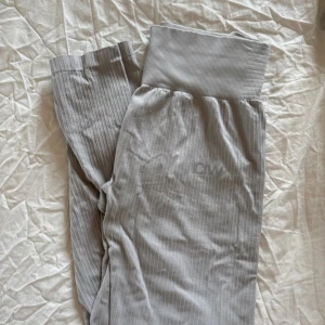 Grå ribbade tights  från ICANIWILL - Snygga grå tights  från ICANIWILL med ribbad struktur och bred, hög midja. Byxorna har diskret logga framtill och är tillverkade i mjukt material som känns skönt mot huden. Perfekta för chill eller träning.