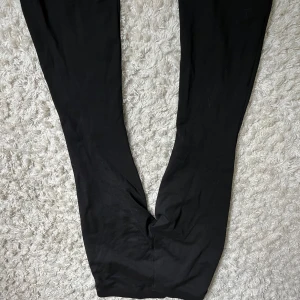 Svarta tighta leggings - Svarta leggings med tight passform och stretchigt material. Perfekta för en avslappnad stil eller att matcha med oversized tröjor. Klassisk modell utan synliga detaljer eller mönster.