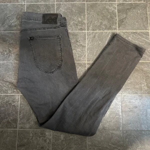 Gråa Lee Jeans - Säljer dessa feta Lee Jeans. Med snygg stilren grå färg i storlek W31/L32. Modellen på bilden är 186cm, 73kg!