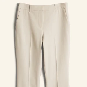 Beiga kostymbyxor med bootcut - Snygga beiga kostymbyxor med bootcut. Byxorna har pressveck, hällor för bälte och fickor i sidorna. 