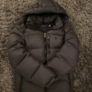 Mörkgrå dunjacka Ralph Lauren - Snygg mörkgrå dunjacka från Polo Ralph Lauren i storlek XS. Riktigt bra skick och passar perfekt om du är runt 173-180. Bara att skriva vid funderingar! Mvh Lucas