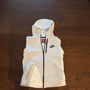 Nike väst  - Det här är en Nike väst som är i bra skick. Det är en äldre model men är riktig fin. Jag kan inte välja storlek på den men den är 147-158 cm, 12-13 år gammla kan ha på sig den.