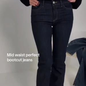 Mörkblå bootcut jeans med broderi - Snygga mörkblå bootcut jeans med midwaist passform. Jeansen har klassisk femficksdesign och coolt gulbroderat zigzag-mönster på bakfickorna. Materialet är jeans med tydliga kontrastsömmar och stretchig känsla för extra komfort.