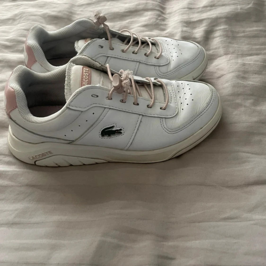 Vita sneakers från Lacoste med rosa detaljer