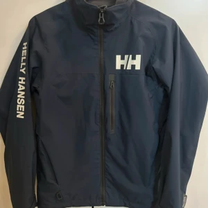 Helly Hansen vindjacka - En skit snygga jacka för bra pris, den är väldigt sparsamt använd och nästan helt ny, nypris på dessa är runt 1500 och pris kan diskuteras vid snabbäfärr🙌🏾🤗.