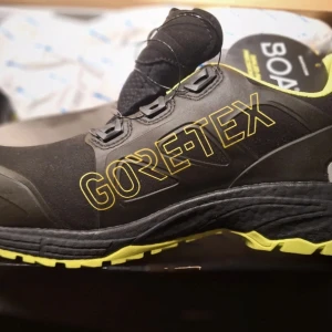 Solid SG80011 Skyddssko Prime Solid - Helt ny Svarta och gula sneakers från Solid Gear med BOA-snörning, Vibram-sula och stora GORE-TEX-detaljer. Skorna har låg profil, robust yttersula och är tillverkade i microfiber och GORE-TEX stretch. Perfekta för dig som vill ha både stil och funktion. Storlek 42 . Prislapp kvar 2800kr 