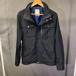 Marinblå field jacket j lindeberg M - Supersnygg field jacket från j lindeberg! Sjukt trendig och snygg. Perfekt för denna höst årsrid! Kan gå ner i pris vid snabb affär!  Funkar även i vår sen! Size M! Modellen är 179 något stor! Perfekt för ca 182-186 kanske! Skick 8/10 begagnad men galant skick! Hör av dig vid frågor eller funderingar ! 🤩