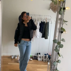 Moncler Gardigan - Säljer en svart pufferjacka med dragkedja framtill. Jackan har en quiltad design och långärmade ärmar, perfekt för att hålla värmen under kyliga dagar. Snygg och enkel att matcha med olika outfits, passar dig som gillar en stilren look.