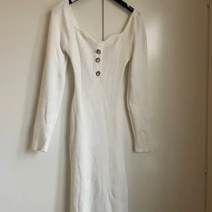 Stickad klänning med knappar - Stickad klänning med silverknappar.