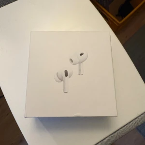 AirPods Pro - Apple AirPods Pro med originalförpackning. Trådlösa hörlurar med aktiv brusreducering och laddningsetui. Viss smuts och repor syns på etuiet, men hörlurarna ser hela ut. Perfekt för dig som vill ha premiumljud och smidig anslutning till Apple-enheter. Ej äkta. Funkar precis som vanliga.