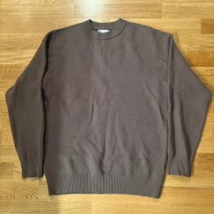 Brun stickad tröja från Zara - En enkel och stilren brun stickad tröja från Zara med rund hals och ribbade muddar vid ärmslut och nederkant. Perfekt för dig som gillar en clean look och vill ha något som funkar till jeans eller chinos. Tröjan har lång ärm och är i mjukt material.