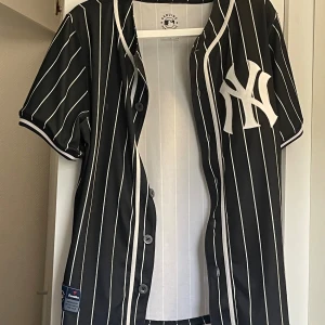 Svartvit randig Yankees pikétröja - Säljer en svartvit randig New York Yankees pikétröja- officiell merch