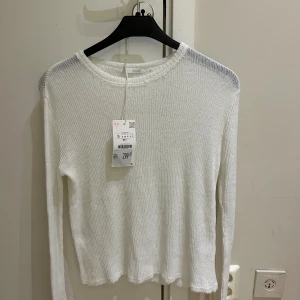 Ny Vit stickad tröja från Zara - Vit stickad tröja från Zara med rund halsringning och lång ärm. Tröjan har en ribbad struktur och lätt vågig nederkant, perfekt för lager-på-lager. Enkel och clean look som funkar till allt. Jag köpte tröjan för 299 kr säljer för 170 kr 