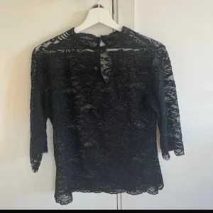 Svart spets topp - En svart spets topp med trekvartsärmar i strl M. Använd mycket få gånger och är i därför mycket bra skick!