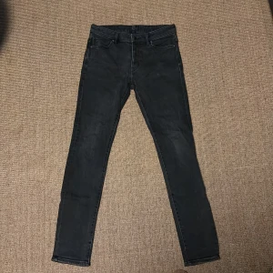 Svarta skinny jeans från Neuw - Svarta jeans från Neuw med smal passform och klassisk femficksdesign. Jeansen har en stilren look med svarta sömmar och detaljer, samt en diskret patch bak i midjan. Materialet är jeans och modellen är modern.