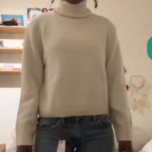 Vit polotröja i mjuk ull - Säljer en stilren vit polotröja med lång ärm och hög krage. Tröjan är tillverkad i mjuk ull och har en klassisk, rak passform som är både bekväm och snygg. Perfekt för att hålla värmen under kyliga dagar. Den är i storlek 14years men skulle säga att den passar XXS💞