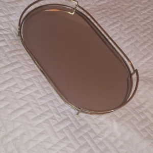 Oval bricka - Fin oval bricka med en spegel, fin dekoration. Lite små avskrap som inte syns om man inte står väldigt nära för att inspektera. 