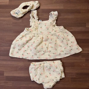 Set med tulpaner - Blommig klänning med tillhörande shorts/bloomers och pannband från RIKIKI i storlek 68 (4-6mån). Upptvättat och använt en gång. Mycket god skick utan anmärkningar. Har en dubblett av detta set i samma storlek, säljes separat på min profil.
