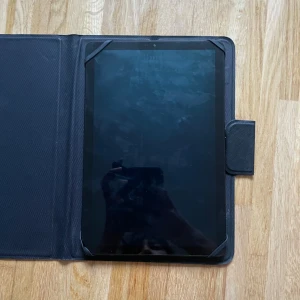 Samsung Galaxy Tab - Samsung Galaxy Tab i svart med AKG-ljud, säljs med skyddsfodral. Skärmen har synliga fingeravtryck men inga tydliga repor eller skador. Baksidan är i fint skick och kameran ser hel ut. Perfekt för surf, streaming och appar.