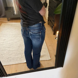 Blå raka jeans  - Snygga blå  jeans med bootcut passform och klassisk femficksdesign. Jeansen har låg midja och är tillverkade i slitstarkt denim med snygga tvättade detaljer och kontrastsömmar. Perfekta för dig som gillar en avslappnad och cool stil.