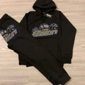 Trapstar svart hoodie London Shooters - Svart hoodie från Trapstar med stort London Shooters-tryck i silver, grått och blått på bröstet. Hoodien har huva med snörning och ribbade muddar. Materialet är mjuk bomull och polyester, perfekt för chill eller streetwear. Snyggt pantermotiv och bold text framtill.