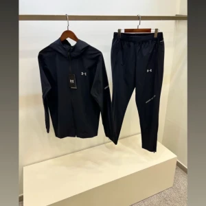 Mörkblå träningsbyxor från Under Armour - Mörkblå träningsbyxor från Under Armour med smal passform och elastisk midja. Byxorna har diskret logga på låret och är tillverkade i ett lätt och funktionellt syntetmaterial som passar perfekt för träning.