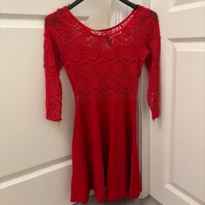 Röd spetsklänning från H&M Divided - Snygg röd kortklänning från H&M Divided med spets upptill och 3/4-ärmar. Klänningen har rund halsringning och ett flowigt kjolparti. Perfekt nu inför jul! Använd endast vid två tillfällen🥰