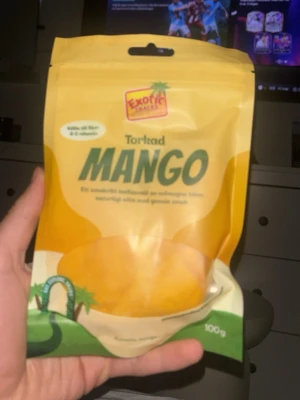 Ingen väst på bilderna - Bilderna visar en påse torkad mango från Exotic Snacks, inte en väst. Ingen information om väst finns att beskriva.