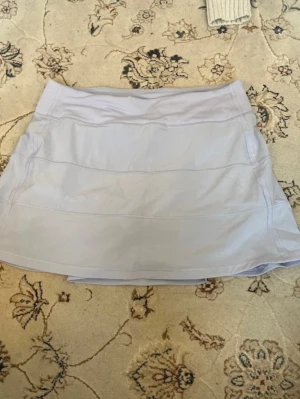 Ljuslila sportkjol från Lululemon - Supersnygg ljusblå tenniskjol från Lululemon med inbyggda shorts!! Strl 6