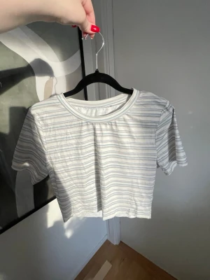 Randig croppad T-shirt - Randig croppad T-shirt med rund halsringning, mjukt och stretchigt material. Oanvänd 